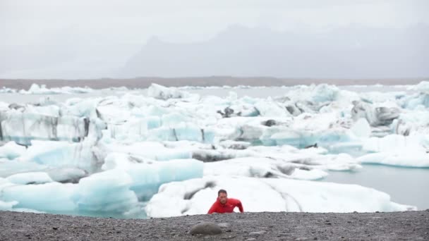 Здоровый молодой человек бегает по айсбергам — стоковое видео