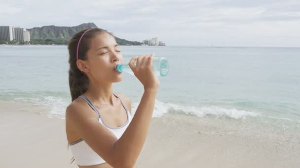 Woman drinking water on beach — Stock Video