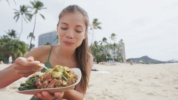 Frau isst hawaiianisches Essen am Strand — Stockvideo