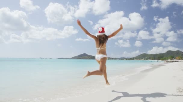 Strandmädchen im Weihnachtsmannhut springen — Stockvideo