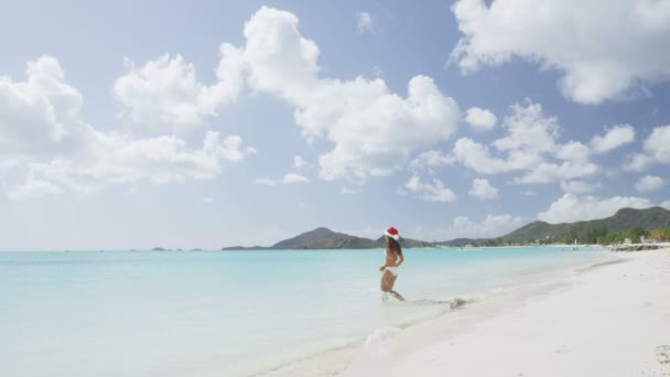 Kobieta w kapeluszu santa na plaży — Wideo stockowe