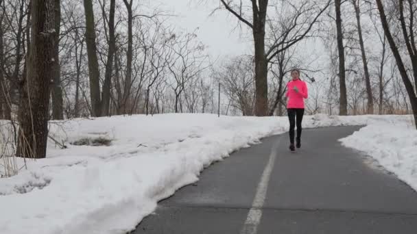Бегущая женщина зимой в снегу — стоковое видео