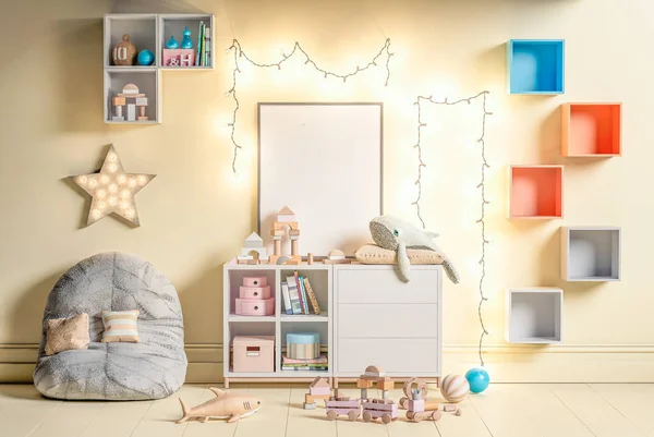 Çocuk odasının içinde boş poster çerçevesi. Çerçeve modeli unisex çocuk odası tasarımı, asılı ışık dizisi