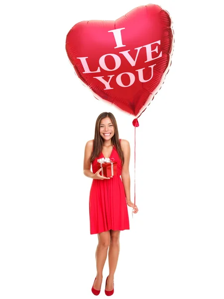 Mujer sosteniendo regalo y globo de corazón — Foto de Stock