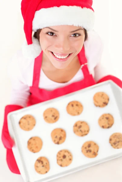 Frau mit Weihnachtsmütze und Plätzchen lizenzfreie Stockfotos