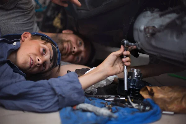 Padre Mecánico Con Hijo Examinando Coche Garaje Reparación Imagen de archivo