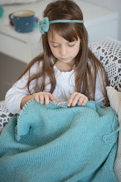 家中用针头编织的可爱小女孩的服装肖像 图库图片