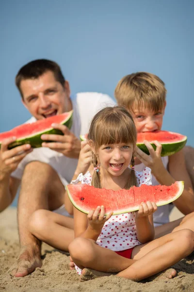 Feliz Padre Con Niños Comiendo Sandía Fondo Del Mar Imágenes de stock libres de derechos