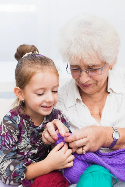 little girl and her granddaughter knitting