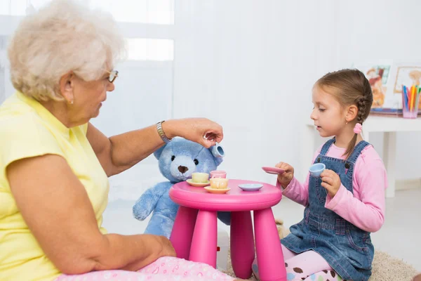 Little girl plays with grandmother — Stock Photo, Image