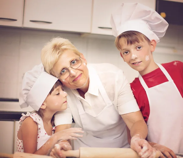 Oma met kleinkinderen bakken koekjes — Stockfoto