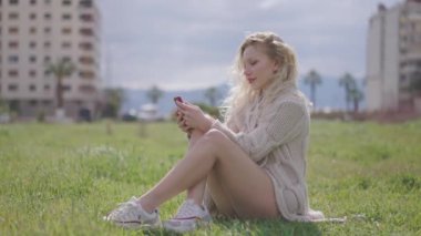 Güzel, seksi ve genç bir kadın akıllı telefon kullanarak sosyal medyada sörf yapıyor, haberleri kontrol ediyor, mobil oyunlar oynuyor ya da dışarıda mesaj yazıyor, cep telefonu aygıtı teknolojisiyle zaman geçiriyor..