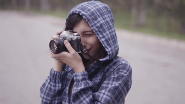 Cute Brunetka Dziewczyna Niebieskim Kapturze Robi Zdjęcia Aparatem Retro Dumny — Wideo stockowe