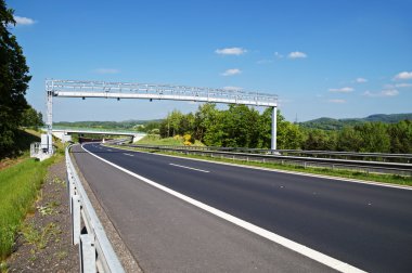 Geçis kapısı ormanlık bir manzara içinde boş bir karayolu üzerinde