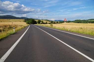 Boş yol ve trafik işareti doğru viraj öncesinde ile kırsal manzara