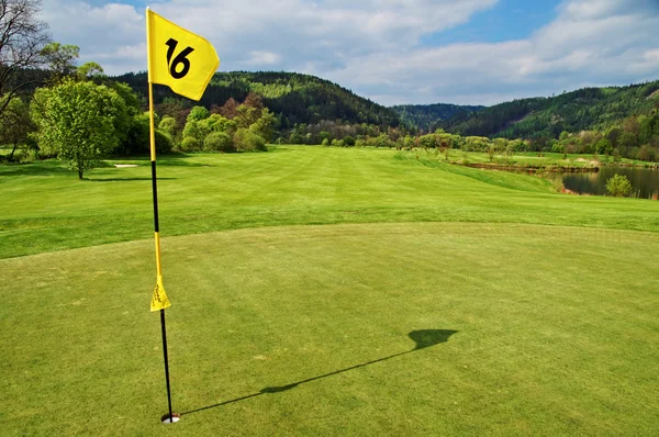 Gelbe Flagge im Loch auf dem grünen Golfplatz — Stockfoto
