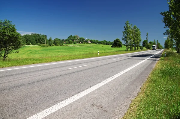 Straße gesäumt von Pappelallee in der Landschaft, in der Ferne vorbei an weißen Lastwagen — Stockfoto