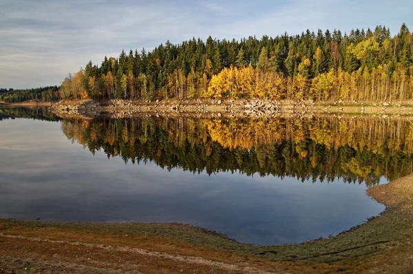 Lake in autumn landscape, on the opposite bank of rocks and forest — Stock Photo, Image