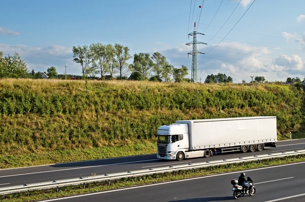 Gang snelweg met vrachtwagen en motorfiets Stockafbeelding