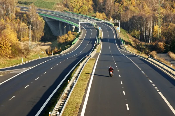 Empty highway leading across the bridge over the valley, motorcycle, electronic toll gates Φωτογραφία Αρχείου
