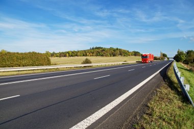 Asfalt yol ile karşıdan gelen kamyon kırsalında, erken sonbahar renkleri