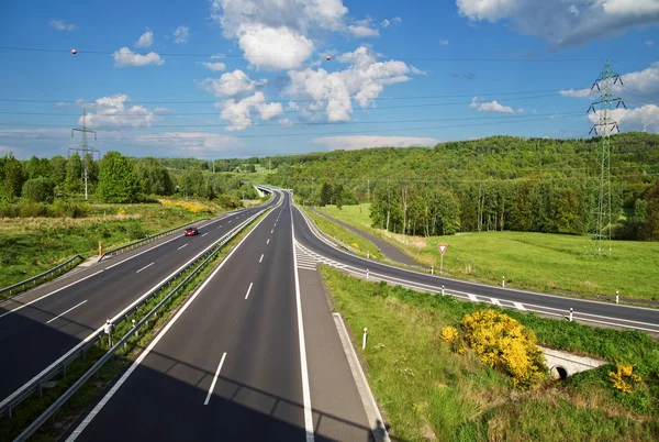 Toegangsweg naar de snelweg in het landschap. Road sign recht van overpad. — Stockfoto