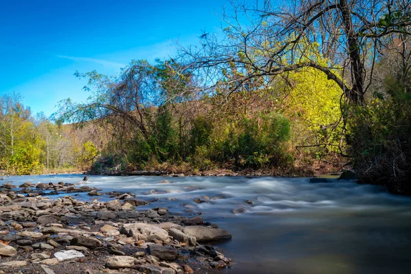 秋の間にアーカンソー州北西部の川の岩の上を流れる水 ロイヤリティフリーのストック写真