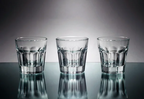 Tres vasos de vodka en el espejo —  Fotos de Stock