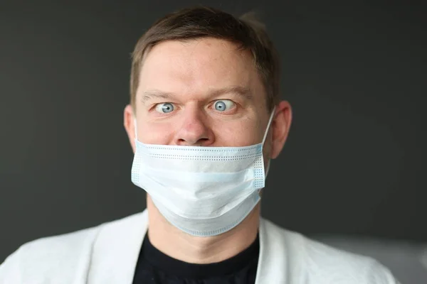 Uomo con una maschera medica protettiva non correttamente indossata. Immagine Stock