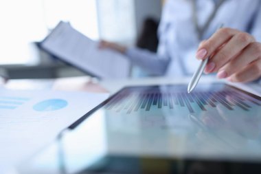 Tablet yakın plan üzerinde çizelge için kadın eli Stylus 'u işaret ediyor