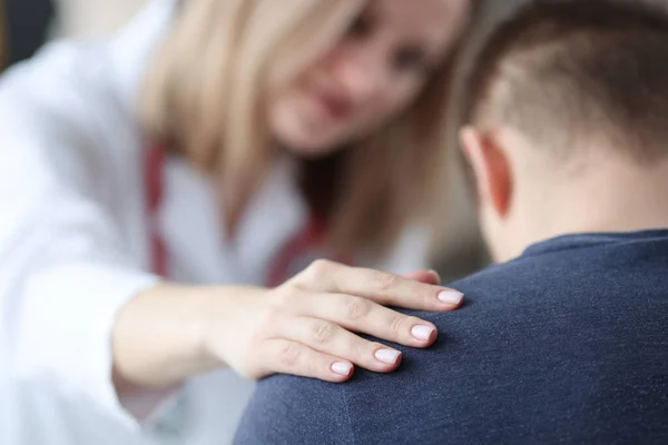 Femme médecin tenant épaule de patient masculin gros plan — Photo