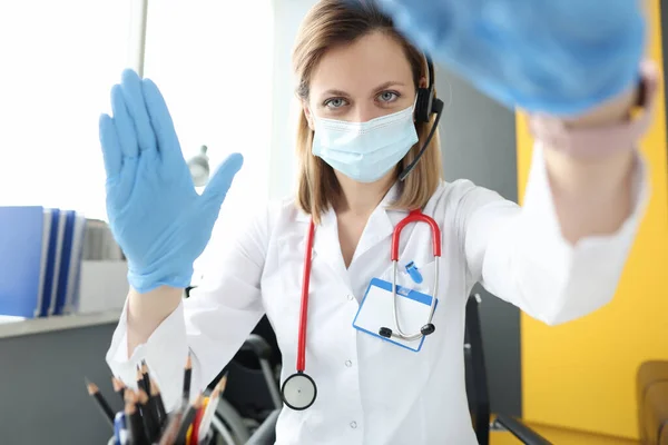 Lekarz w masce i rękawiczkach powitanie pacjenta na ekranie monitora — Zdjęcie stockowe