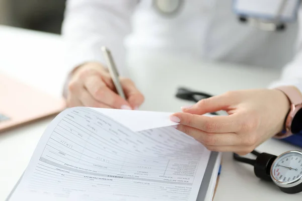 Medico che scrive con penna a sfera in pazienti anamnesi Fotografia Stock