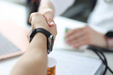 Doktor ofiste hastayla el sıkışıyor.