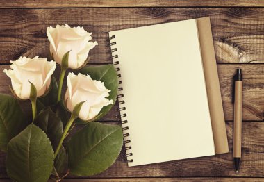 Defter ve kalem ile beyaz gül çiçek