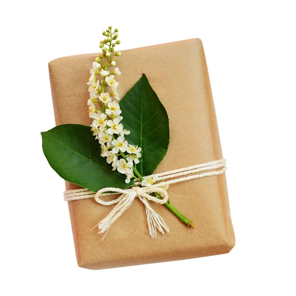 Package wrapped in craft paper and tied with flowers — Stock Photo, Image