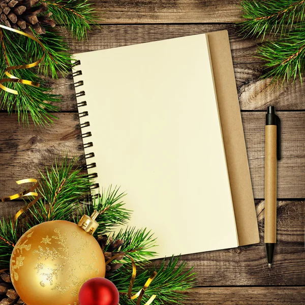Cuaderno y bolígrafo con decoraciones navideñas en madera —  Fotos de Stock