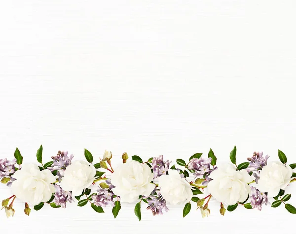花园玫瑰和紫丁香花在白色木制背景的边界排列 平躺在床上顶部视图 — 图库照片