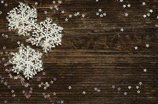 Snowflakes on dark wood — Stock Photo, Image