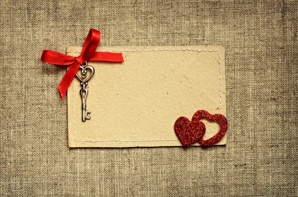 Wenskaart met rood lint en een sleutel voor Valentijnsdag — Stockfoto