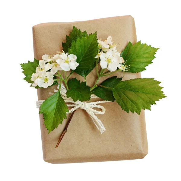 Package wrapped in kraft paper and tied with a rope and flowers — Stock Photo, Image