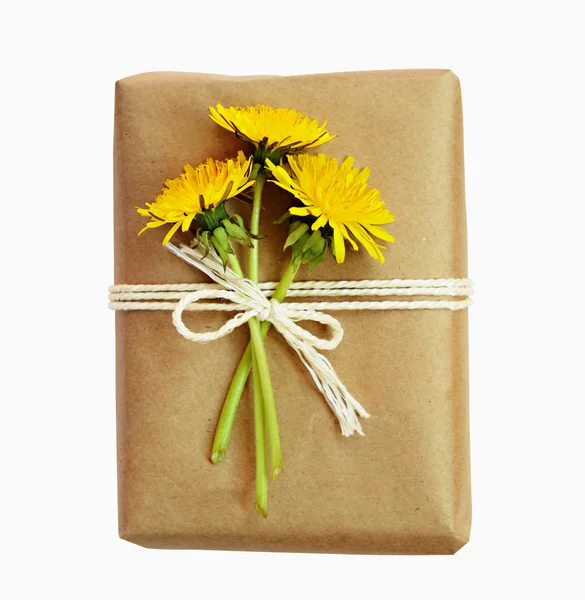Pacchetto avvolto in carta e legato con una corda e fiori — Foto Stock