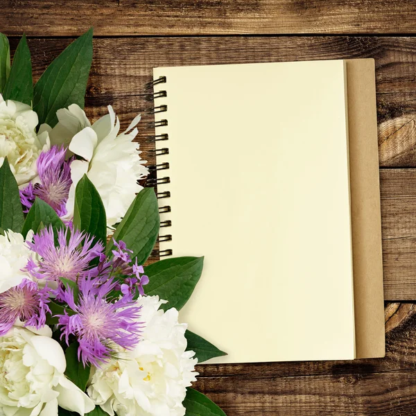 Ramo de flores peónicas y silvestres con bloc de notas — Foto de Stock