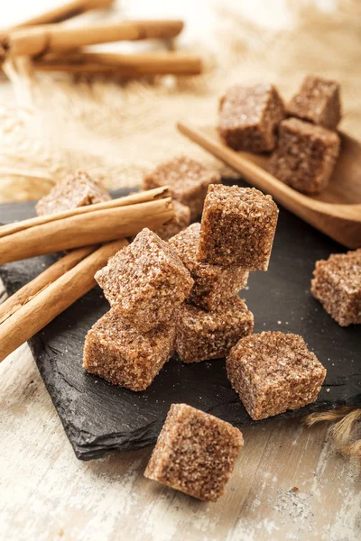 Braune Zuckerwürfel mit Zimtstangen — Stockfoto