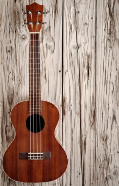 ukulele on aged wood background clipart