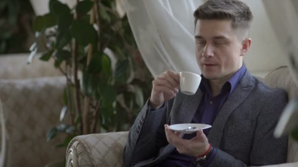 Junger Mann trinkt Kaffee — Stockvideo