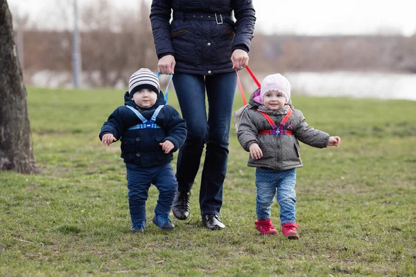 Mamma går med sina två barn bort koppel — Stockfoto