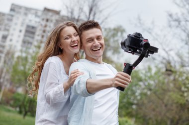 Mutlu genç aile gimbal steadycam onun kamera ile video selfies alarak