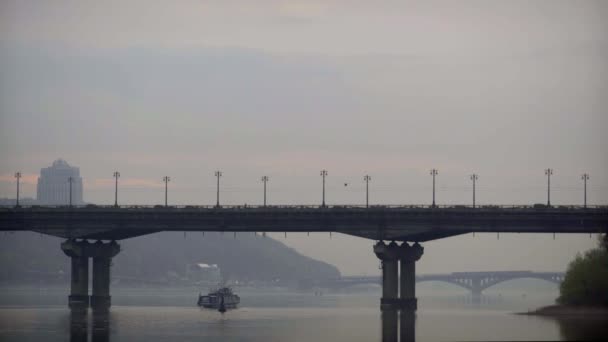 Ein Schiff fährt unter der Brücke über den Fluss — Stockvideo