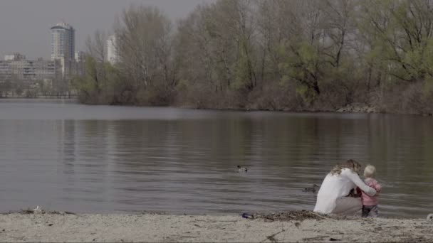 Madre e hijo en una orilla del río — Vídeos de Stock